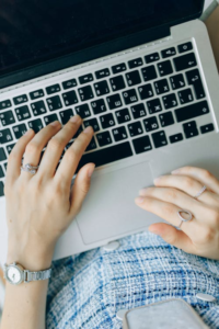 hands typing on a laptop keyboard